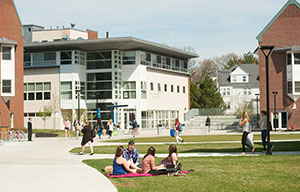 dorms outside students sitting on grass outside dorms