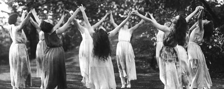 women dancing in a circle with hands raised