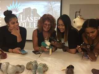 Students and Professor Lynn Blake observing beautiful shoe artifacts from the LCF